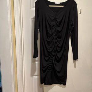 Black long sleeved cocktail dress slit in front.